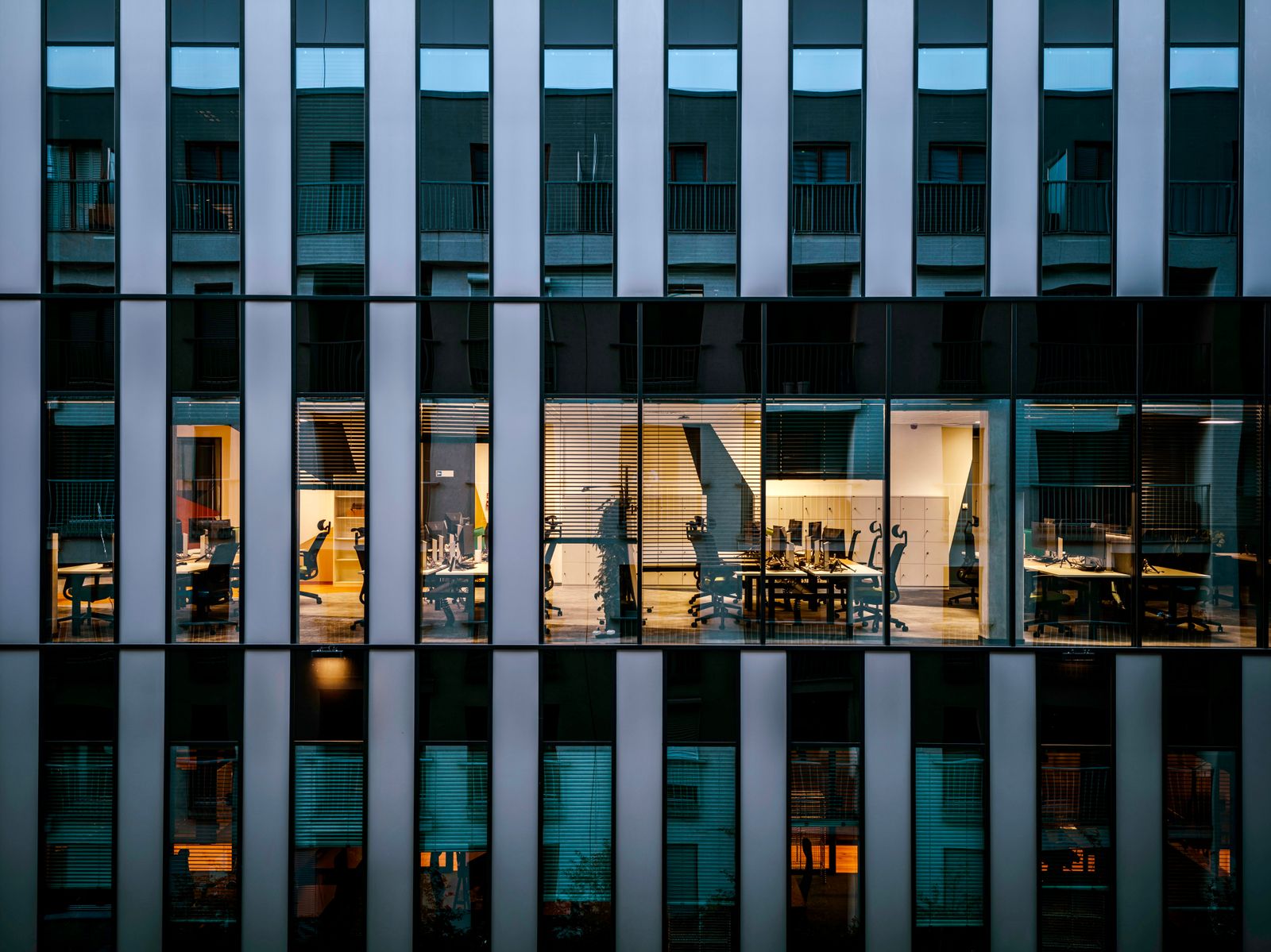 Lit office lobby glass at dusk