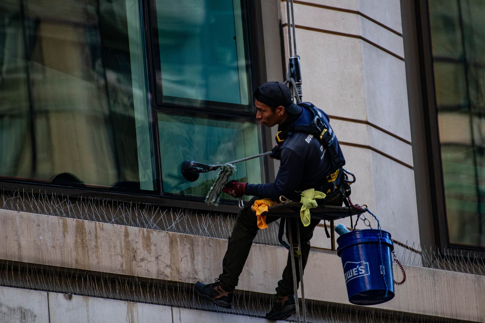 Rope access technician cleaning glass on a Detroit high-rise